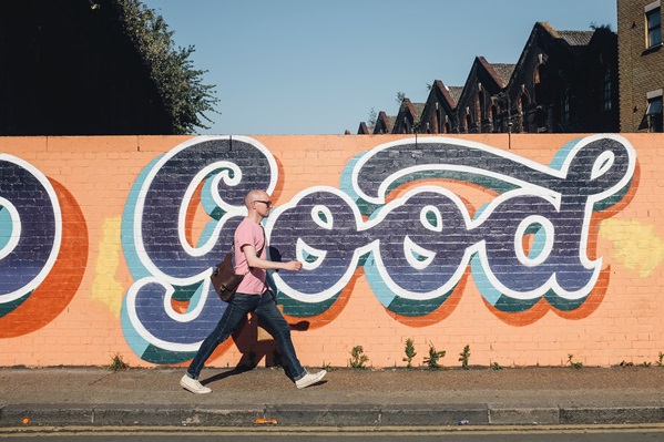 Man with motivation walking past Graffiti